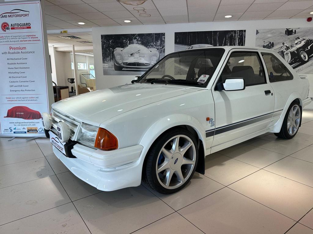 A pristine 1985 Ford Escort 1.6 Turbo RS in white, featuring its sleek 3-door design and sporty appeal.