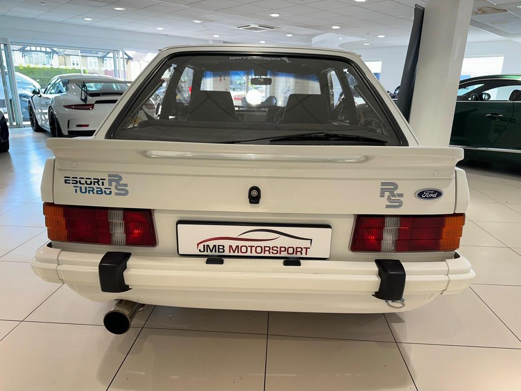 A pristine 1985 Ford Escort 1.6 Turbo RS in white, featuring its sleek 3-door design and sporty appeal.