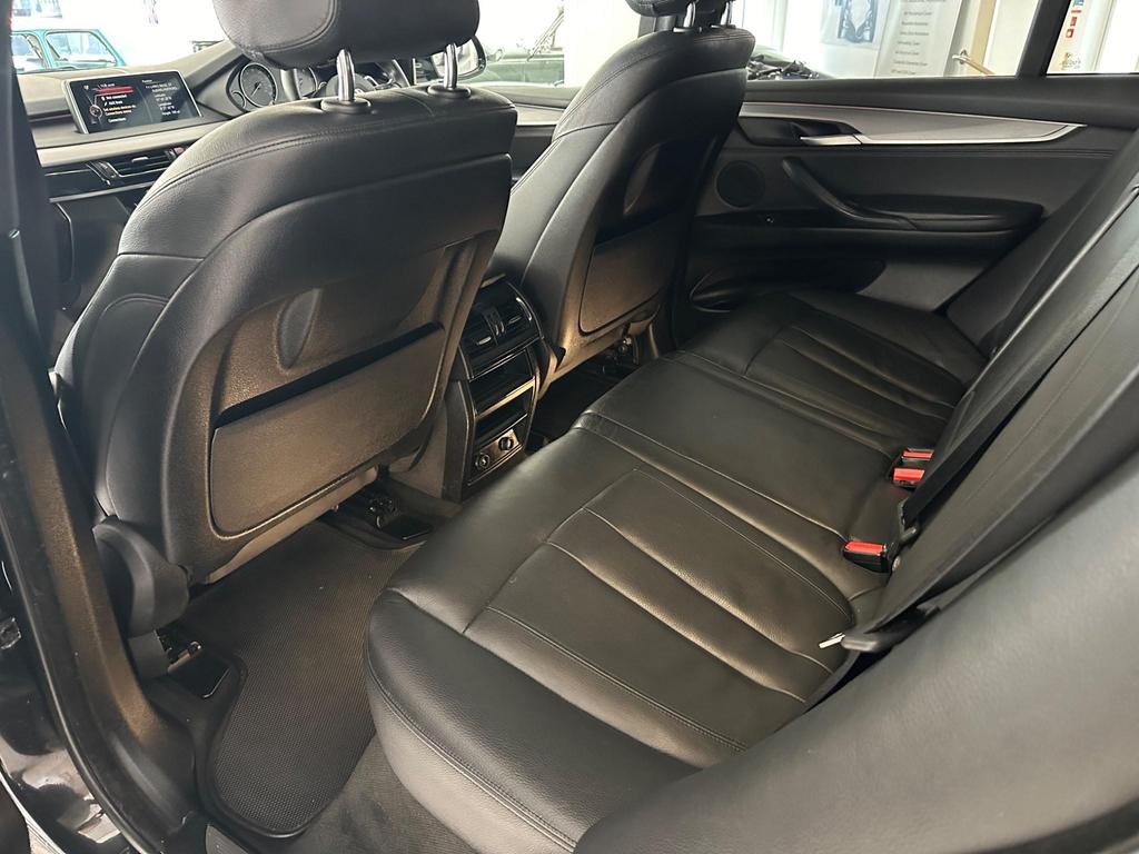 Luxurious interior of the BMW X5 3.0 30d M Sport Auto xDrive featuring black Dakota leather seats, ambient lighting, and a spacious layout with split-folding rear seats.
