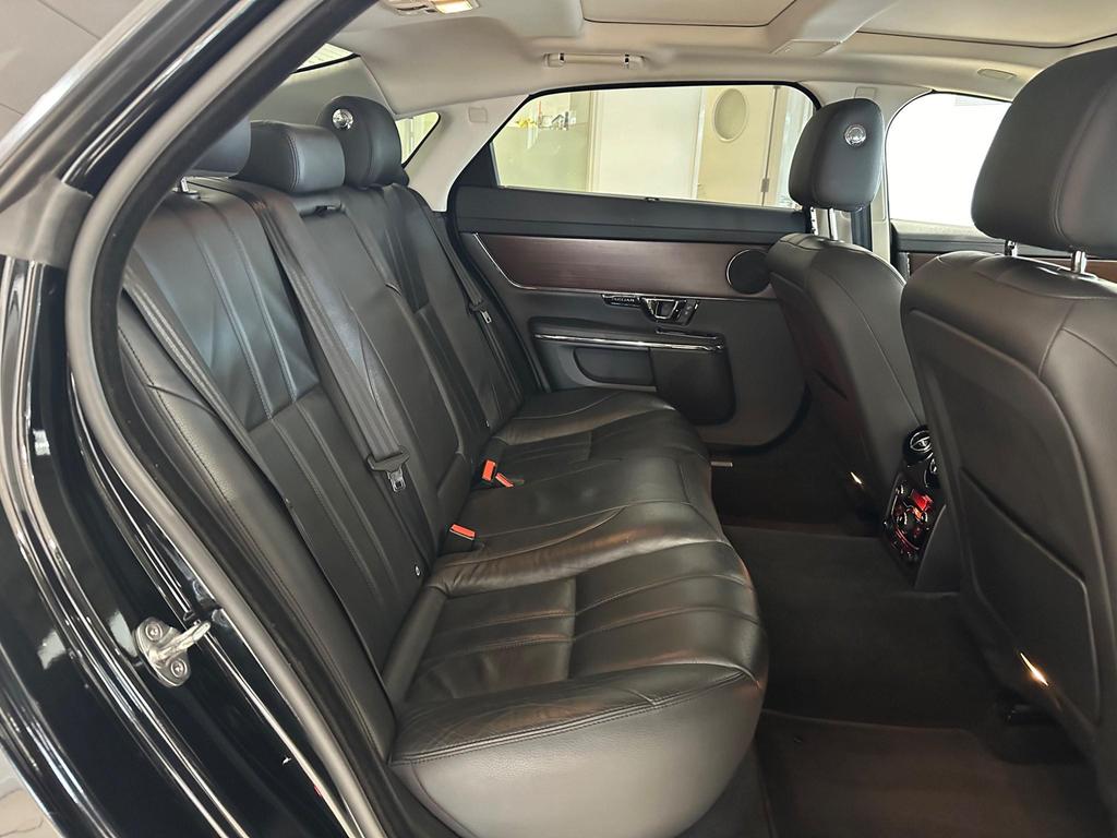 Interior of the Jaguar XJ 3.0D V6 Luxury LWB with a luxurious leather finish and advanced touchscreen display.