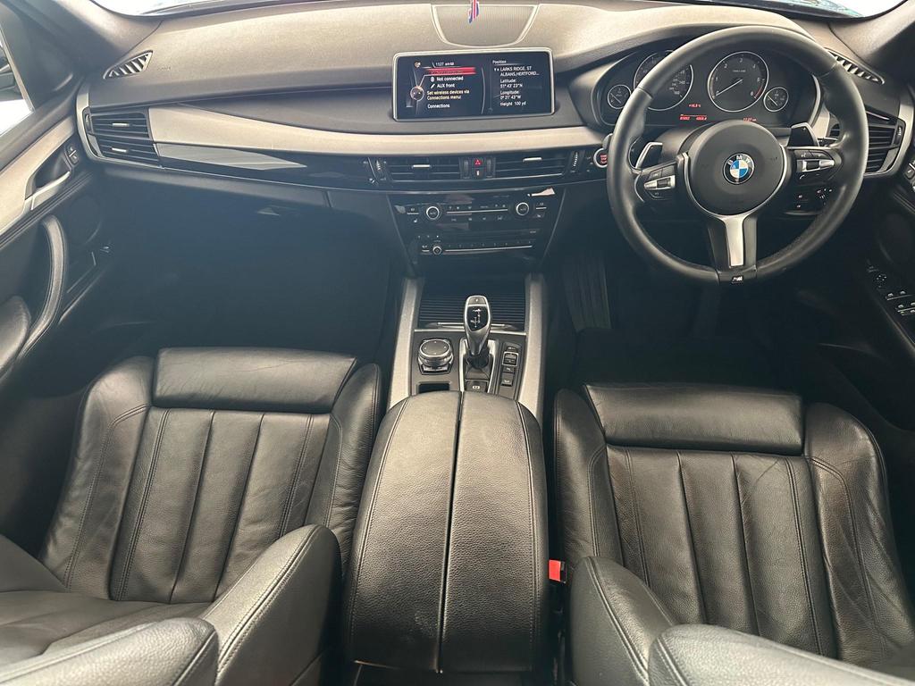 Luxurious interior of the BMW X5 3.0 30d M Sport Auto xDrive featuring black Dakota leather seats, ambient lighting, and a spacious layout with split-folding rear seats.