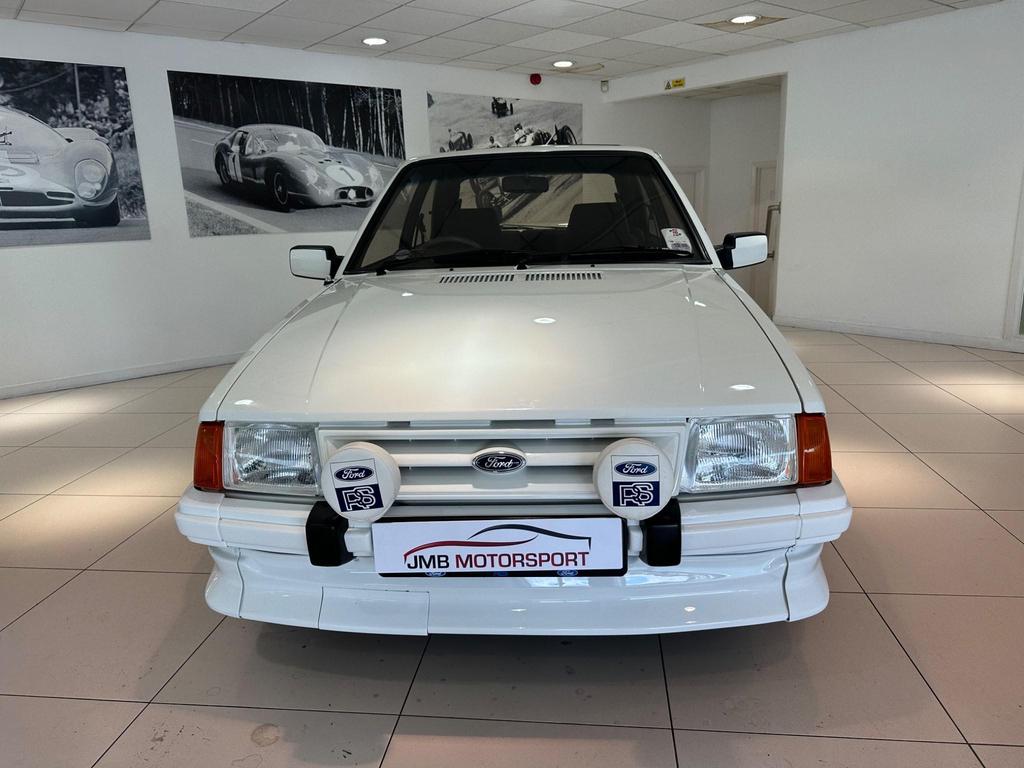 A pristine 1985 Ford Escort 1.6 Turbo RS in white, featuring its sleek 3-door design and sporty appeal.