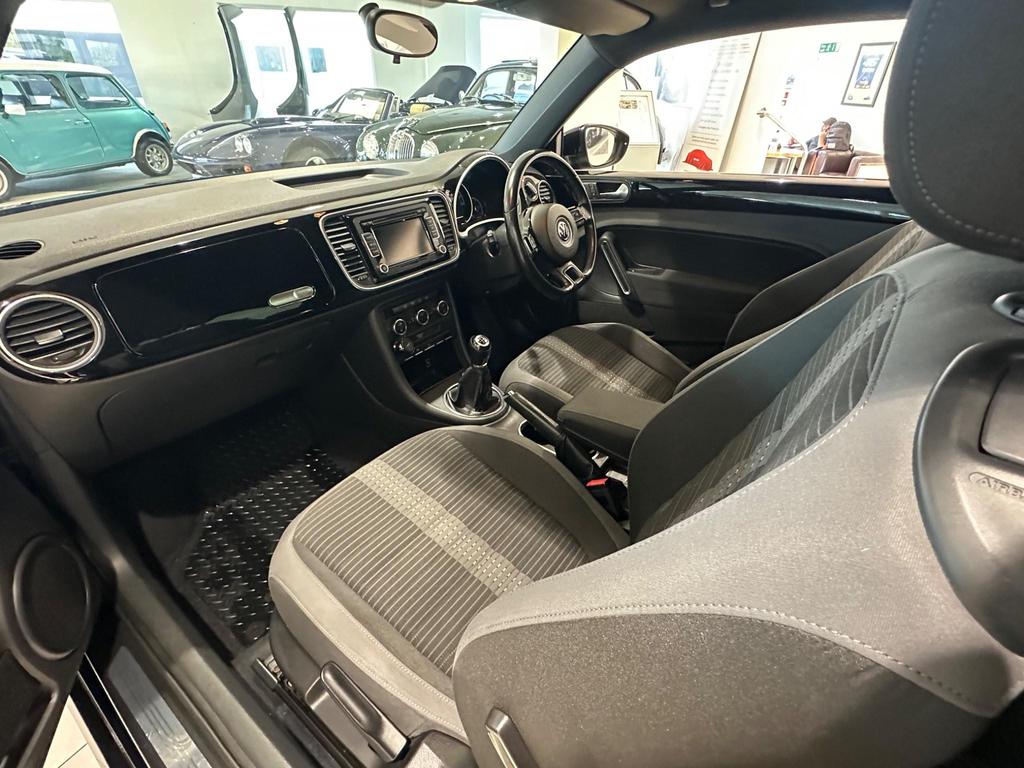 Interior of the VW Beetle featuring comfortable Ferris cloth seats and a classic dashboard layout.